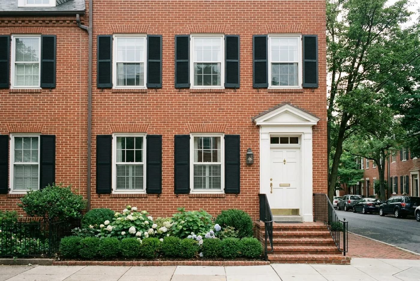A customer's photograph of a red-brick colonial townhouse with black shutters